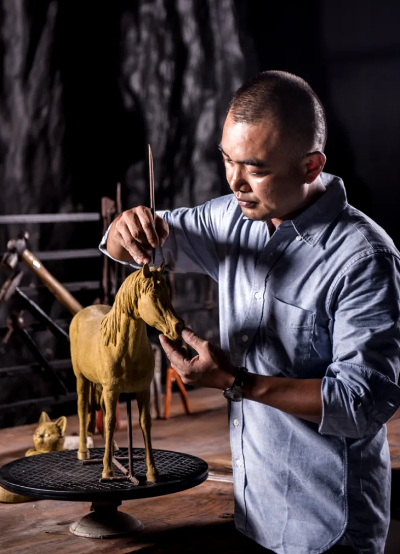 Man sculpts a house figureine